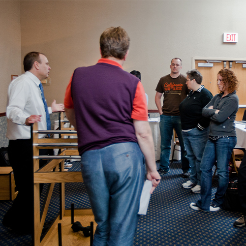 Jim Mecham teaching large group of students