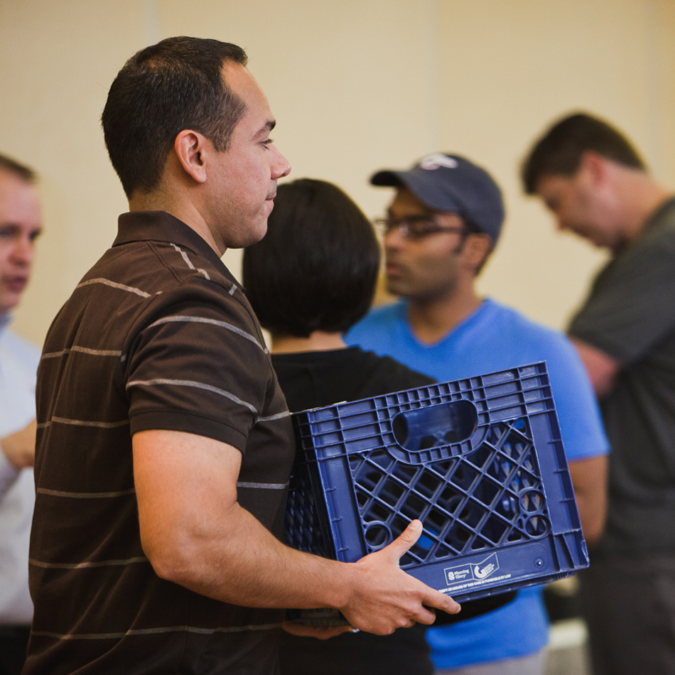 Man lifting blue plastic crate