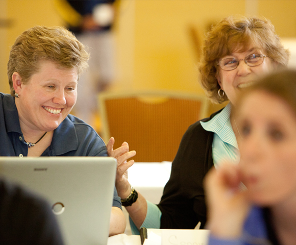 Two friends smiling during course