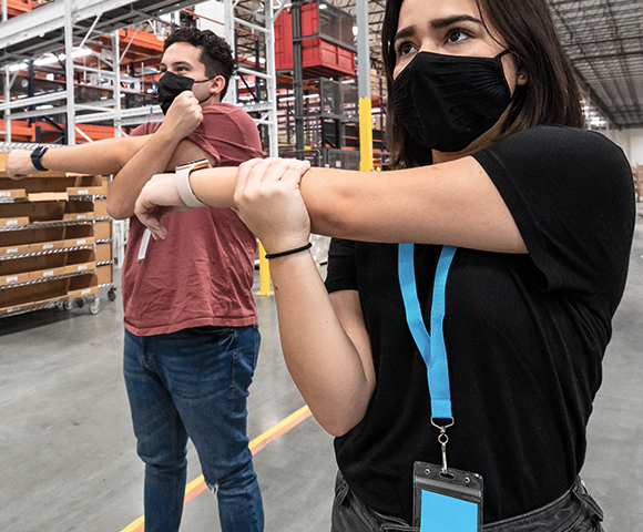 Employees stretching in warehouse