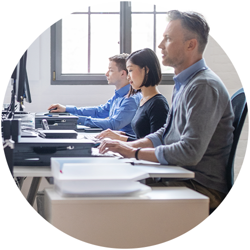 Three employees typing on computers